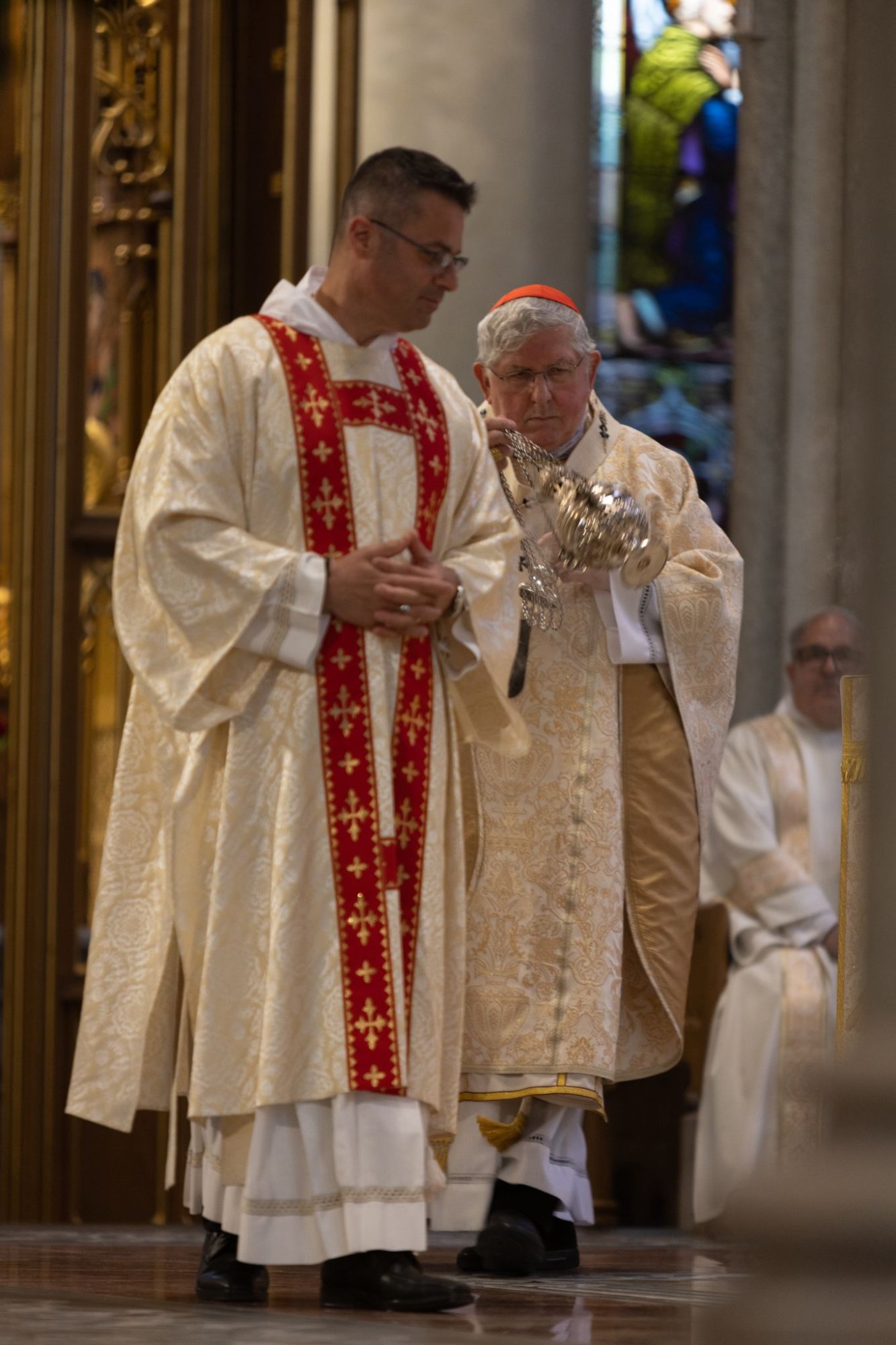 A deacon vested in dalmatic and stole assists at the altar