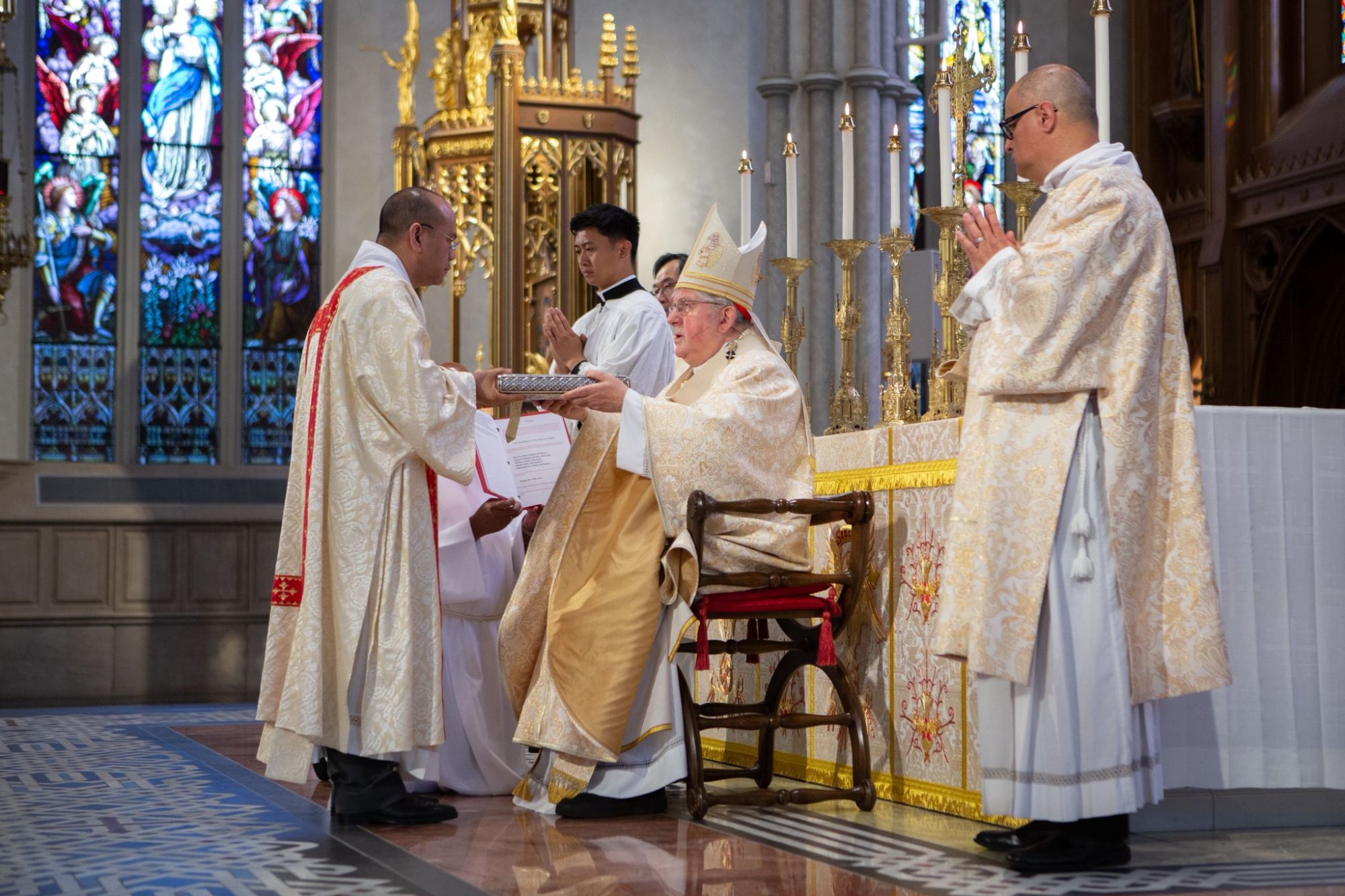 A newly ordained deacon receives the Book of the Gospels from the Bishop during the Rite of Ordination